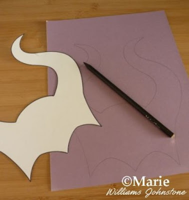 Horn template cut out from thick card and traced around onto purple cardstock with a pencil