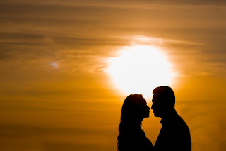 Eine Partnerschaft braucht gute Momente, auf die beide Personen zurückgreifen können, wenn die Zeiten schwerer sind. Ein sich liebendes Paar im Sonnenuntergang, das sich nahe ist.