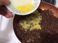 Melt butter, add beef, onions and garlic. Season with salt and pepper; stir and fry until meat is cooked through. Stir mixture until meat is cooked through, then add the cinnamon, nutmeg, herb mixture and parsley, stir to combine. Add the tomato sauce and wine*, stir and simmer for about ½ hour. Remove from the heat and when cooled add the beaten egg*, stir to combine.