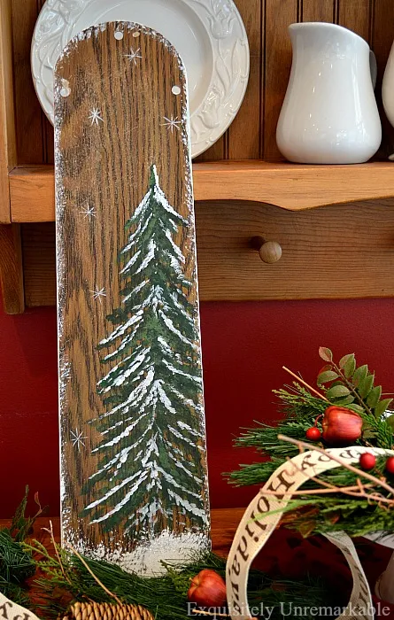 rustic christmas wooden sign made out of fan blade on table with Christmas decor about it