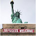 Cuelgan manta de bienvenida a refugiados en la Estatua de la Libertad