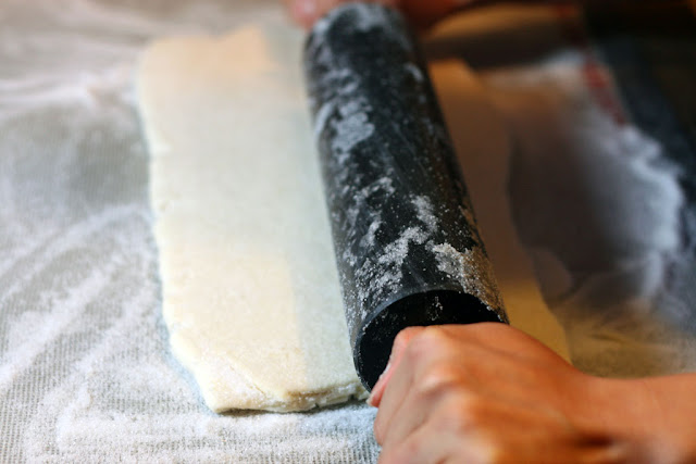 dough being rolled by a granite rolling pin