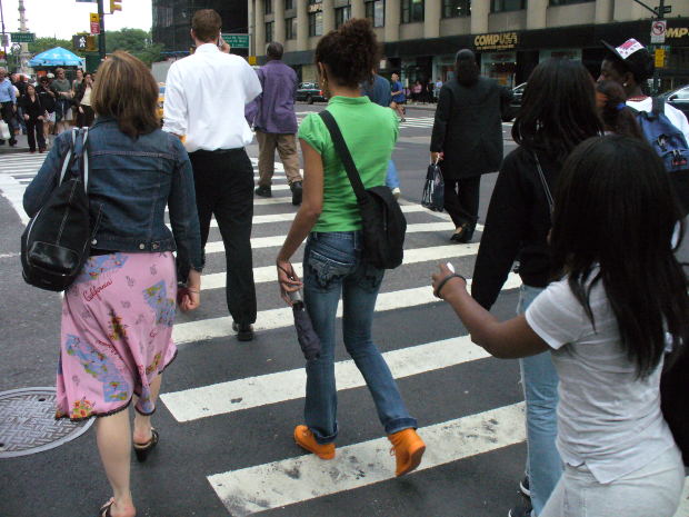 Personas caminando sobre un paso peatonal Personas caminando sobre un paso peatonal