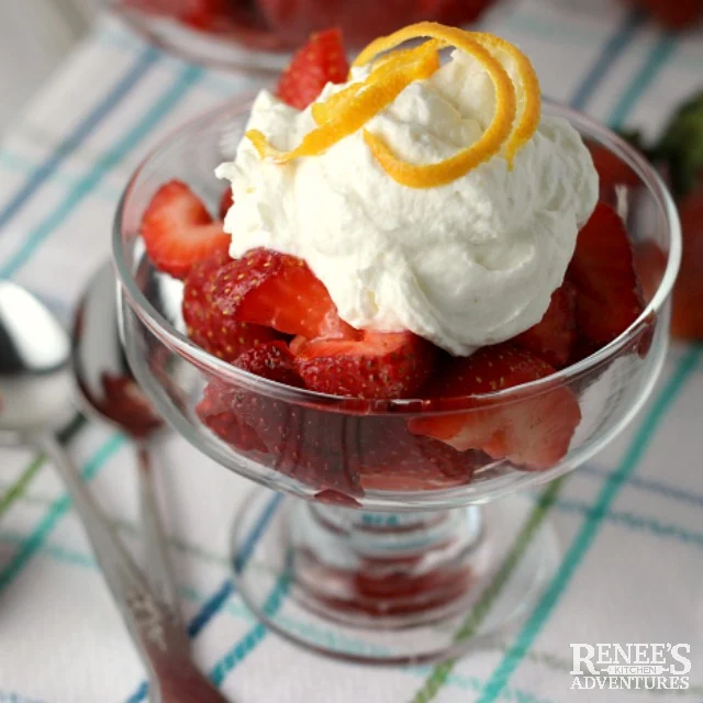 Strawberries Romanoff by Renee's Kitchen Adventures in a glass, ready to serve, topped with orange peel