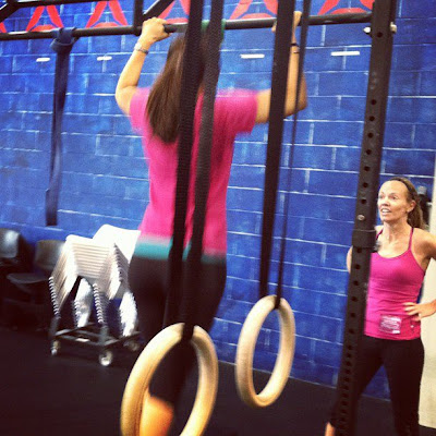 Heather Hart cheers on another woman doing pullups during a workout at the Reebok CrossFit One facility