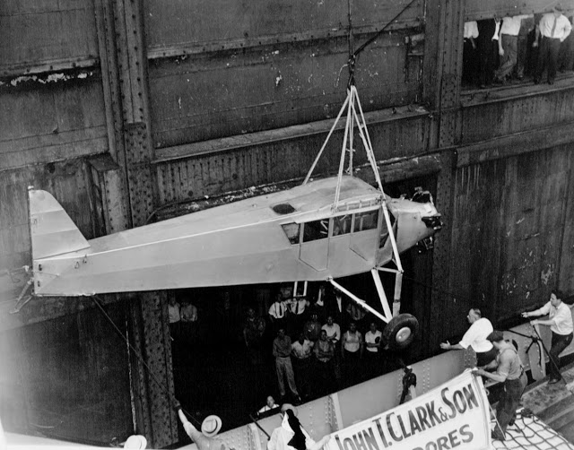 Douglas Corrigan's 'rattletrap' plane returning to NYC via ship. The aircraft, without wings, being lowered from the ship. A crowd of workmen and sailors watch the event. 1938. Wrong Way and other stories of pilots. marchmatron.com Douglas Corrigan's 'rattletrap' plane returning to NYC via ship. The aircraft, without wings, being lowered from the ship. A crowd of workmen and sailors watch the event. 1938. Wrong Way and other stories of pilots. marchmatron.com