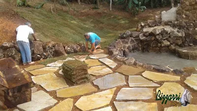 Bizzarri plantando a grama esmeralda junto ao lago de carpas com a mureta de pedra, com pedras ornamentais, tipo pedra moledo, com os caminhos de pedra com pedra cacão de São Tomé, obra em sítio em Nazaré Paulista-SP. 05 de abril de 2017.
