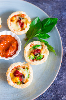 cups made with bread, filled with pizza toppings,sauce and cheese and baked