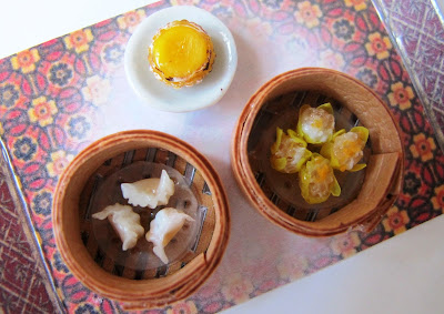 Miniature bamboo steamers holding dim sums and other traditional Hong Kong treats.