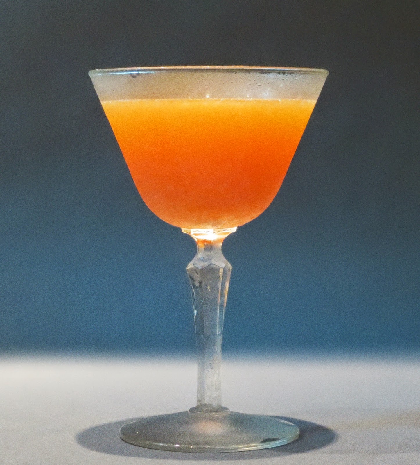 cocktail, stem glass with a film of frost, faceted stem, neutral background