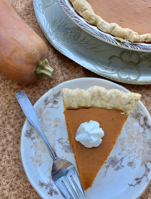 Slice of roasted honeynut squash pie on a serving plate.