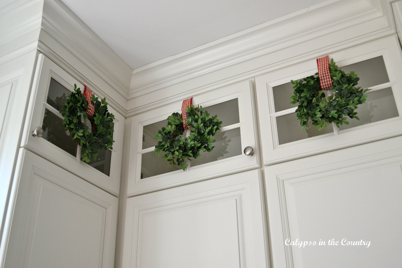 Mini Wreaths on Glass Kitchen Cabinets