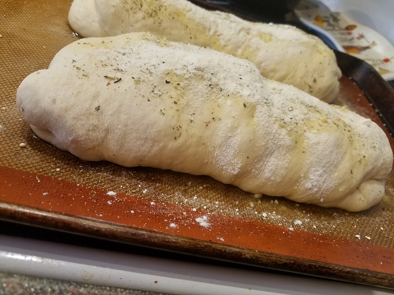 pizza dough stuffed with sausage, cheese, olives, pepperoni, tomoatoes, peppers, in homemade pizza dough called stromboli