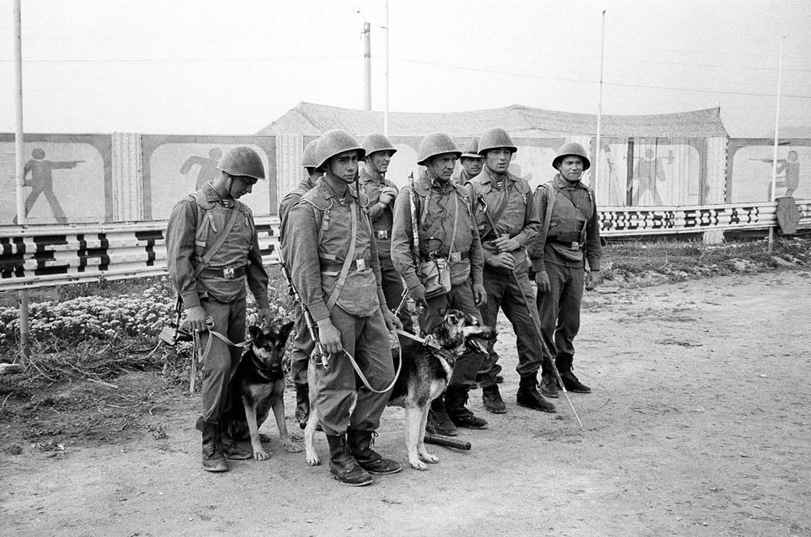 Soviet soldiers work with two German Shepherd dogs trained to sniff out explosives in and around their base near Kabul on May 1, 1988.
