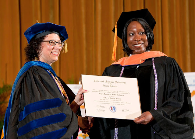 Dean Romano shakes a student's hand at graduation