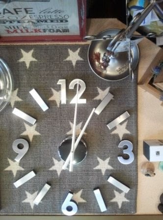 Reloj auto-adhesivo plateado sobre alfombra estrellas