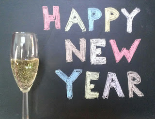 happy new year sign in colored chalk with champagne glass