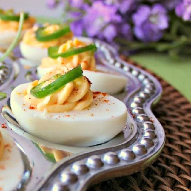 Sriracha Deviled Eggs with Candied Jalapeno Peppers close up on tray 