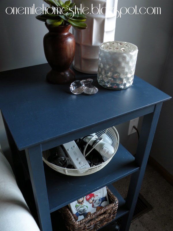 Navy blue side table with video game storage