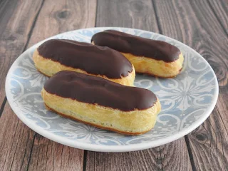 3 mini eclairs on a blue and white plate