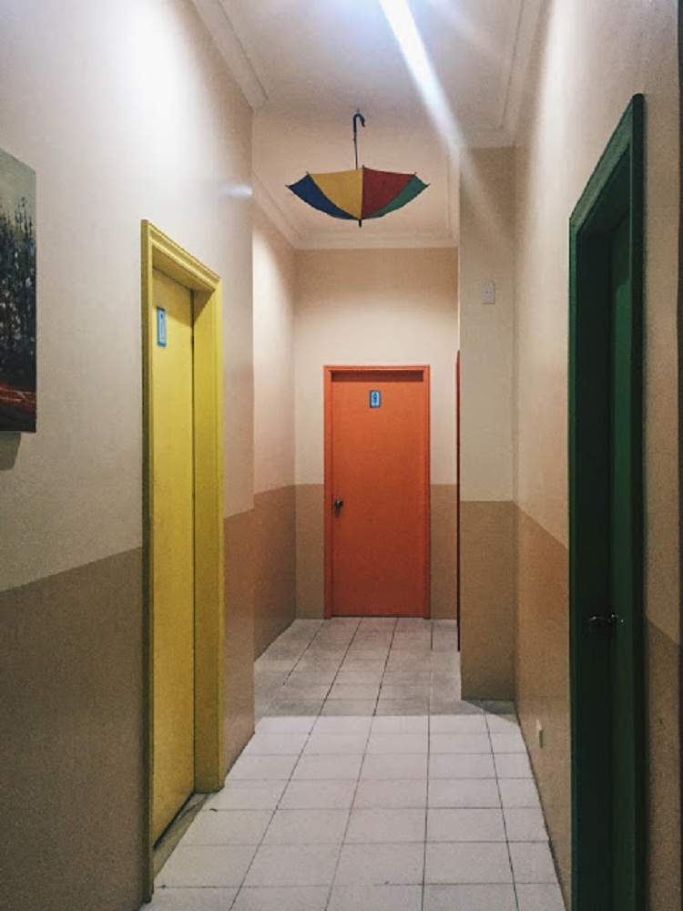 The hallway and the colored bedroom doors Le Village