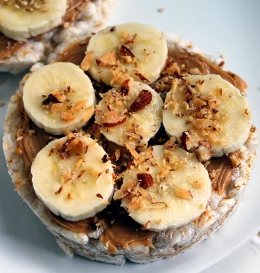 Peanut butter, honey, and banana rice cakes with toasted sesame seeds and crushed almonds