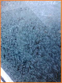 frost covered car window.  The steering while inside can hardly be seen.