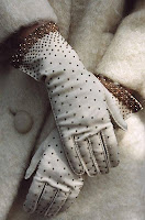 woman's crossed hands wearing old fashioned long white gloves