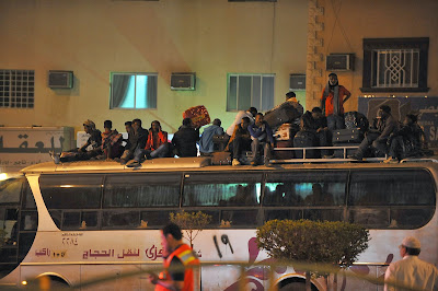 Illegal migrants sit on the roof of a police bus with their belongings on November 13, 2013 before being transferred to a center in the capital Riyadh ahead of their deportation. Renewed clashes on November 13 between Saudis and illegal migrants, targeted in a nationwide campaign, killed one person and wounded 17. A Sudanese died as Saudis clashed with illegal migrants in the southern Riyadh neighborhood of Manfuhah, scene to riots over recent days. Last week, the ultra-conservative kingdom began rounding up thousands of illegals following the expiry on November 4 of a final amnesty for them to formalize their status.
