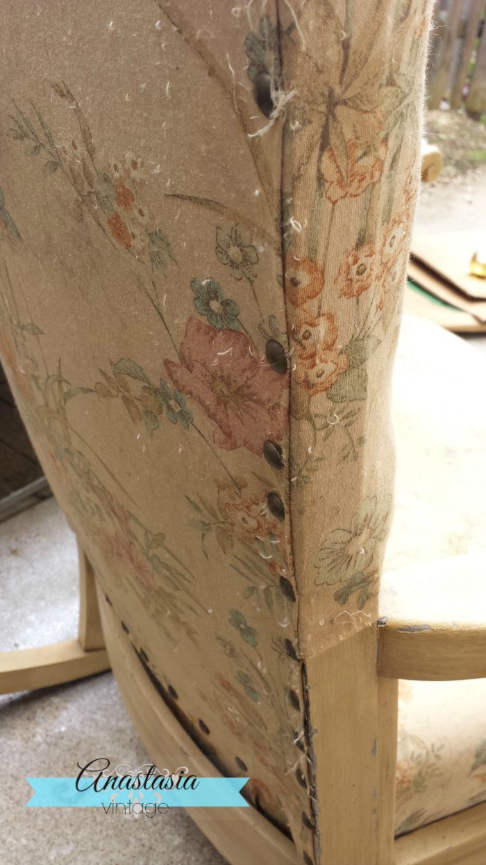 side of vintage rocking chair with floral upholstery and tacks