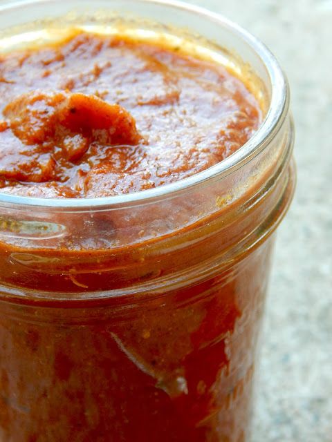 Side view of red enchilada sauce in a glass mason jar.