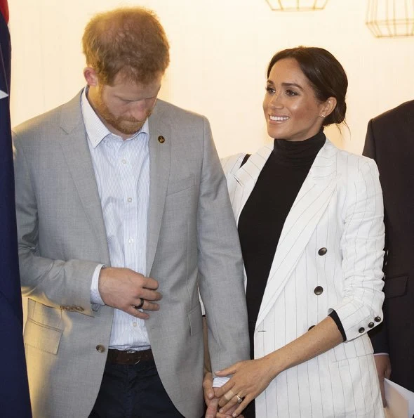 Meghan Markle wore L'agence Brea pinstriped linen and cotton-blend blazer, Wolford Colorado bodysuit, Outland jeans, carried Oroton Avalon bag.