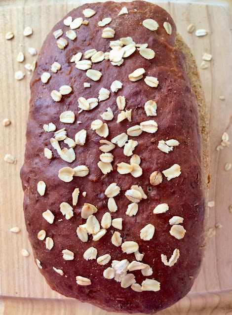 Loaf of baked oatmeal molasses bread.