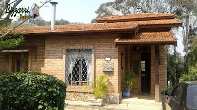 Casa com base de pedra, tipo revestimento de pedra com chapas de pedra moledo em casa com parede de tijolo a vista em condomínio em Atibaia-SP.