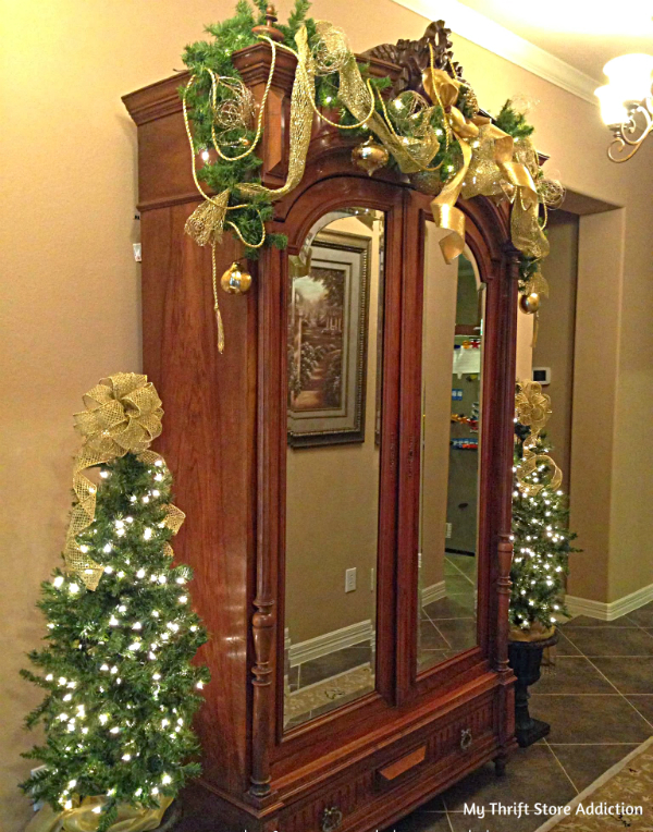 Classic traditional Christmas greenery and gold adorned armoire shared by a Texas reader! mythriftstoreaddiction.blogspot.com Traditional greenery and gold adorned armoire