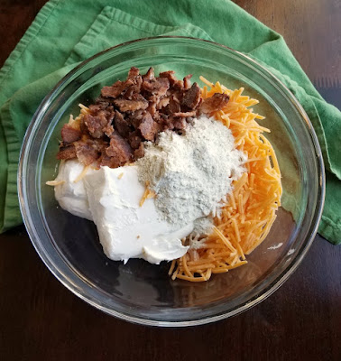 bowl filled with cream cheese, ranch seasoning, cheese and bacon