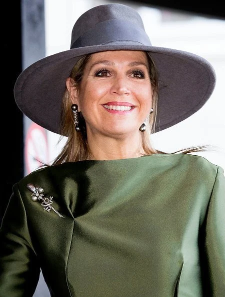 Queen Maxima wore a green dress by Natan and carried Chanel bag. . Queen wore Natan shoes. Natan is a fashion house founded by Edouard Vermeulen