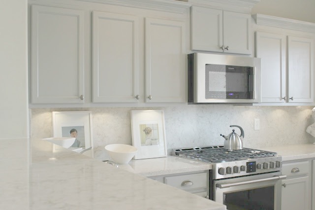 Serene chic simple Nordic French kitchen with grey cabinets and Soprano quartz countertop and backsplash