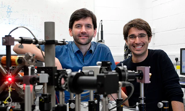 Image Attribute: Amalio Fernández-Pacheco, Principal Investigator of the project (left) and Dédalo Sanz- Hernández, lead author of the work (right) posing with the optical system used at the University of Cambridge to read information from 3D magnetic nanostructures. / Dédalo Sanz-Hernández / SINC