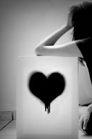 Kara sevdayı anlatan üzerinde siyah bir kalp olan bir tabloya yaslanmış üzüntülü kız