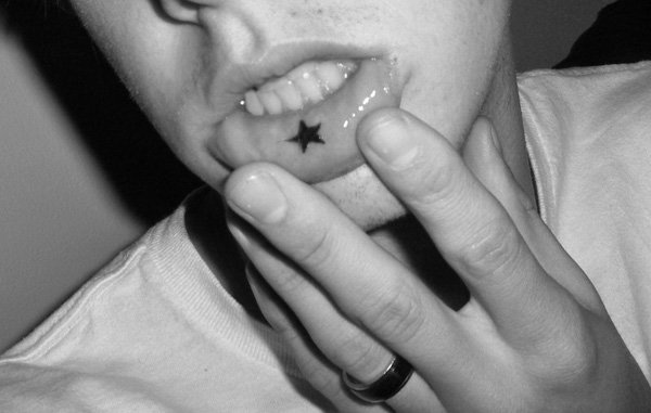 mujer con tatuaje de estrella en el labio inferior