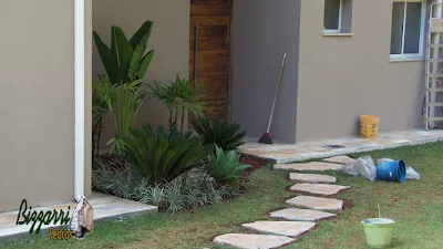 Caminho no jardim com pedra cacão de Carranca com junta de grama com a execução do paisagismo em casa em condomínio em Piracaia-SP.