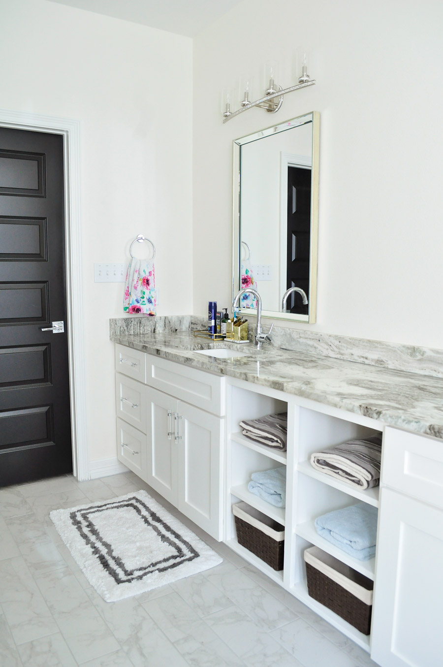 An alabaster white bathroom with black interior doors and chrome and mirrored finishes. An alabaster white bathroom with black interior doors and chrome and mirrored finishes.
