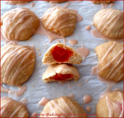 Cherry Cola Cookies, a cherry flavored dough encasing a marashino cherry, topped with a cherry cola drizzle | Recipe by BakingInATornado.com | #recipe #cookies