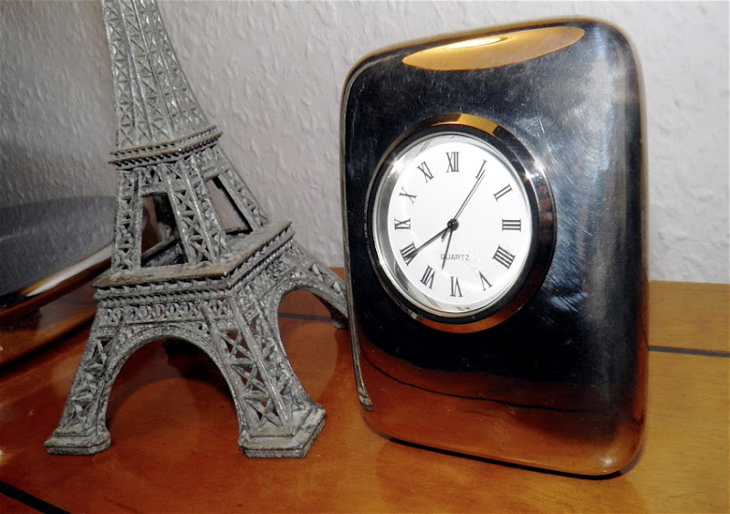 Uhr und Miniatureiffelturm auf dem Schreibtisch