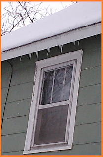 Icicles hanging from the roof above the second level window.  Possibly 5-6 inches long