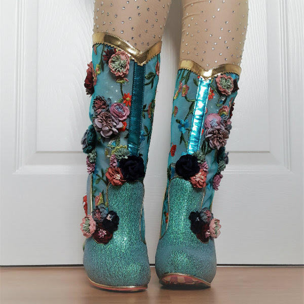 wearing Irregular Choice Angelica front leg tilted in aqua cowboy style sparkly boots