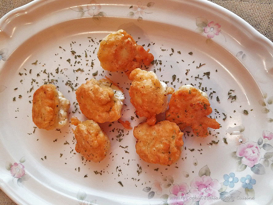This is how to make a crispy coated batter fried cauliflower recipe with herbs and spices as an appetizer. The cauliflower is cut up into small bite size pieces and then coated with a tempura batter and pan fried