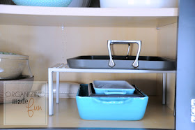 Use an expandable shelf to hold more serving dishes inside a cupboards :: OrganizingMadeFun.com