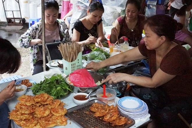 The women traders in Dong Xuan Market are eating breakfast